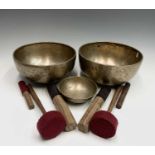 Two large Tibetan/Himalayan hand beaten singing bowls and one smaller, each with two mallets, bowl