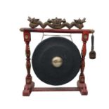 A Chinese carved wood and metal gong, with a painted frame, height 101cm, width 98cm, depth 33cm.