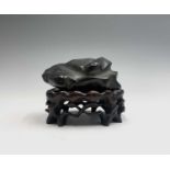 A Chinese black hardstone 'Scholars Rock', on a hardwood stand, height of hardstone 6cm, width 12.