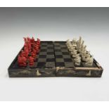 A Chinese Canton carved ivory chess set, 19th century, red stained and natural, kings 7.5 cm high,