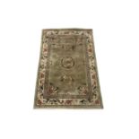 A Chinese 'art silk' rug, the green field with flowers and birds, within an ivory similar border,