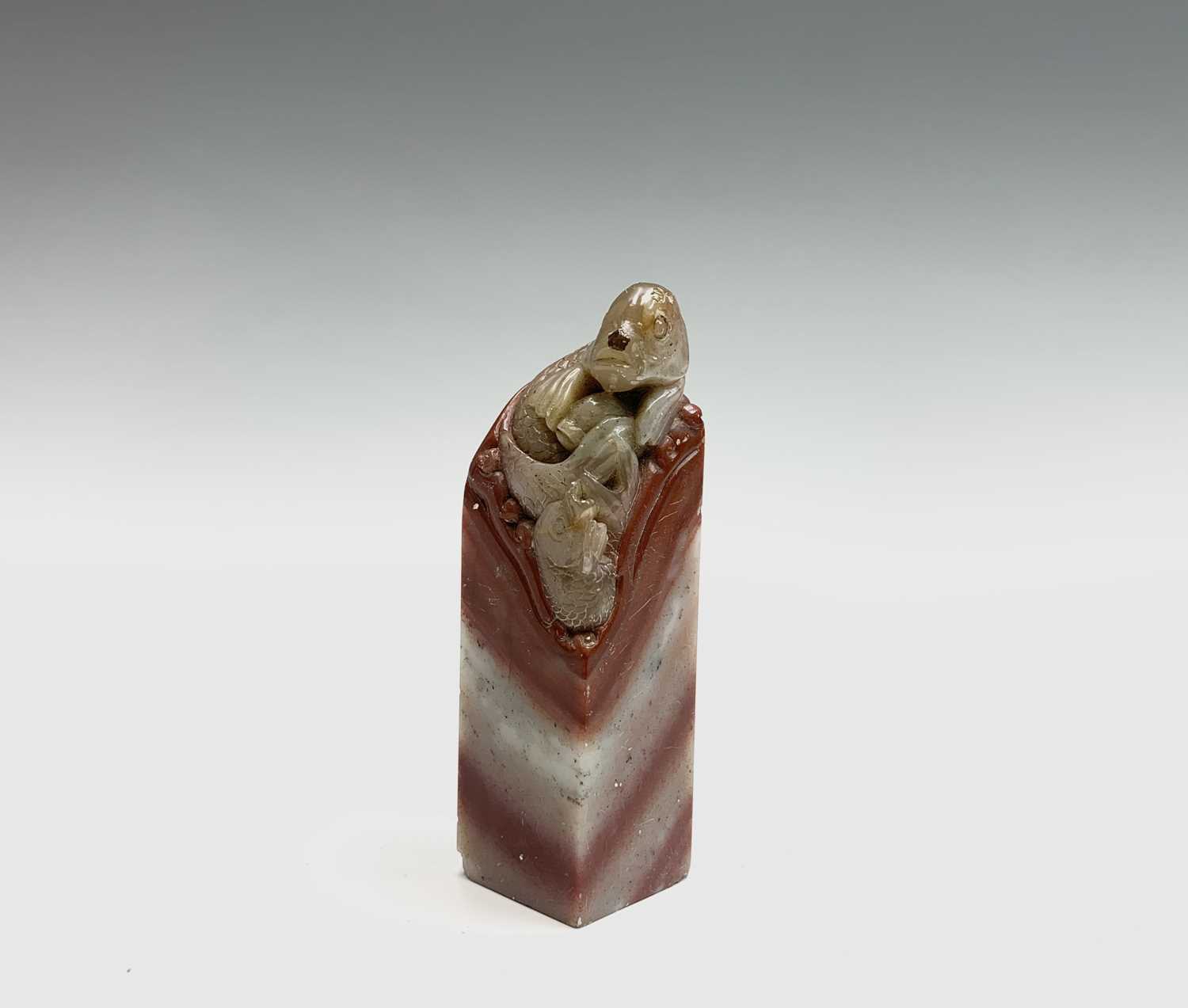 A Chinese hardstone seal, 19th century, surmounted by a carved carp, height 7.5cm.