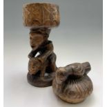 A West African carved wood figure, modelled seated astride a leopard and supporting a covered bowl