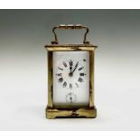A French brass carriage clock, the white enamel dial with subsidiary alarm dial, striking on a bell,