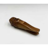 A treen nutcracker, early 20th century, carved as a smiling gent wearing a cap, length 15.5cm.