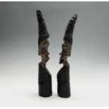 A pair of central African ethnic carved hardwood figures, of tusk form, with male and female mask