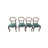 A set of four Victorian walnut balloon back dining chairs, with a padded seat on cabriole legs,