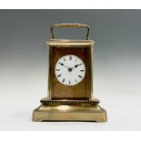 A French brass carriage timepiece, late 19th century, with circular enamel dial, height 16cm.