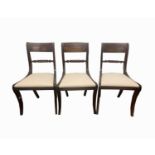 A set of three Regency mahogany dining chairs, each with a turned and fluted horizontal splat and