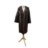 A long sable fur coat, lined in dark brown silk, velvet lined pockets, wide collar, one central hook