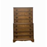 A George III style walnut chest on chest, 20th century, with eight long drawers on bracket feet,