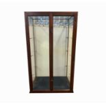 A late Victorian mahogany glazed display cabinet, with a pair of doors and three glass shelves,