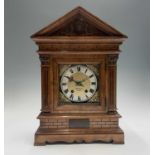 An Edwardian walnut architectural cased mantel clock, the German movement with silvered chapter ring