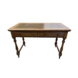 An oak writing table, early 20th century, tne leather inset top above two frieze drawers on turned