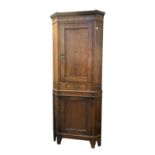 A George III inlaid oak corner cupboard, on a later base, height 217cm, width 85cm.