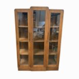 An Art Deco style teak glazed bookcase, with three doors and a plinth base, height 158.5cm, width