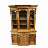 A pine breakfront bookcase, with three glazed doors, the lower part with three frieze drawers