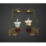 A pair of rare late Victorian Romany wall mounted brass cherub oil lamps, each with cranberry