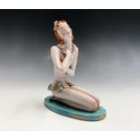 A French Art Deco pottery figure, circa 1930, modelled as a kneeling young female wearing a grass