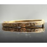 A 9ct gold Greek key pierced hinged bangle 9.2gm