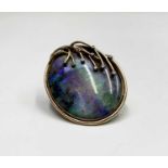 A contemporary oval opal brooch, set in 9ct gold, over the stone there lies eight naturalistic