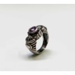 A modern silver ring with an amethyst in ornate setting.