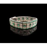 A tasteful yet opulent 1920s French 18ct white gold bracelet set with diamonds and emeralds in