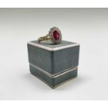 An oval ruby of 1.3ct set in a gold ring within a border of diamonds each approximately 0.10ct 4.