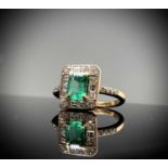 An emerald and diamond ring the principal stone measures a hint over 1ct, about it are baguette