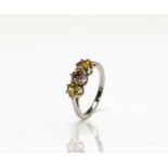 A platinum three stone ring with a central diamond set between yellow sapphires 4.1gm