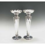 A pair of silver vases, the necks with chased floral bands below wide scalloped rims.London