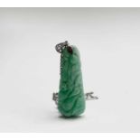 A 1920s carved jade pebdant mounted in white gold or platinum and set a diamond on white gold