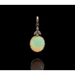 An Edwardian gold-mounted opal pendant, it hangs from a diamond set trefoil and a plain gold ring.