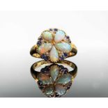 An 18ct gold early 20th c. ring with a pentamerous flower head, the petals are pear-shaped opals