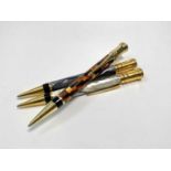 Three Parker Duofold International ballpoint pens, one amber check, one white pearl with black and