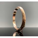 A chased 9ct gold hinged bangle 9.4gmCondition report: Clasp works and clicks nicely. A few small