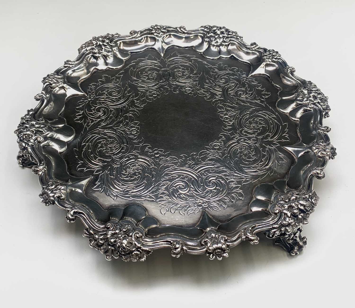 A William IV Silver Salver with scrolling acanthus leaf and floral decoration on three cast feet