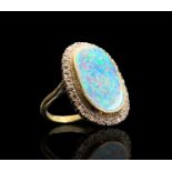 An impressive 18ct (unmarked) gold oval opal ring with a diamond border. 25.8 x 17.6mm head size,8.