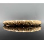 A 14ct gold hinged fluted bangle 13.7gmCondition report: internal dimensions 5.5x6cm. Clasp works