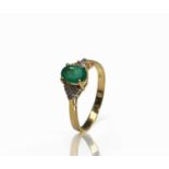 An 18ct gold ring set with an emerald flanked by a trio of diamonds to each shoulder 2.