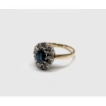 An 18ct gold ring with an oval sapphire and diamond cluster 3.5gmCondition report: Needs cleaning.