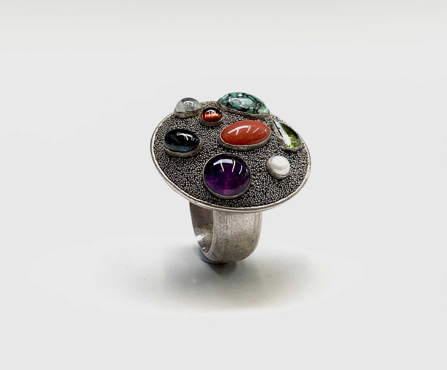 Silver ring, the round table-top surface set with various semi-precious stones.