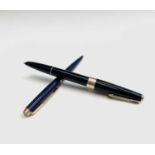 A Parker 17 black fountain pen with gold trim and a Parker 180 lapis ballpoint