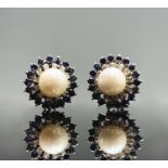 A pair of 18ct white gold earrings each with a pearl of 8.5mm within bands of diamonds and sapphires