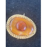 An amber and gold brooch
