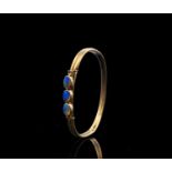 A 9ct sprung core bangle mounted with three opals 7.2gm