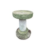 A composition stone bird bath, the circular top raised on a column with stepped base. Overall height