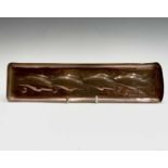 A Newlyn copper pen tray, circa 1910, repousse decorated with four fish, stamped mark, length 30cm.