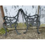 A pair of green painted cast iron bench ends. Height 80cm.