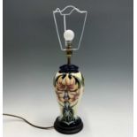A Moorcroft 'Sweet Lily' pattern table lamp. Height 38cm (to top of brass fitting).Condition report: